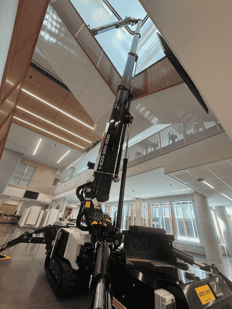 Crawler-mounted aerial work platform in interior staircase of office building photo 1 by SOSEQUIPMENT